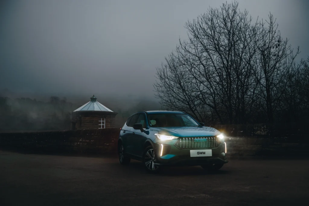 GWM Haval at dusk with headlights on.