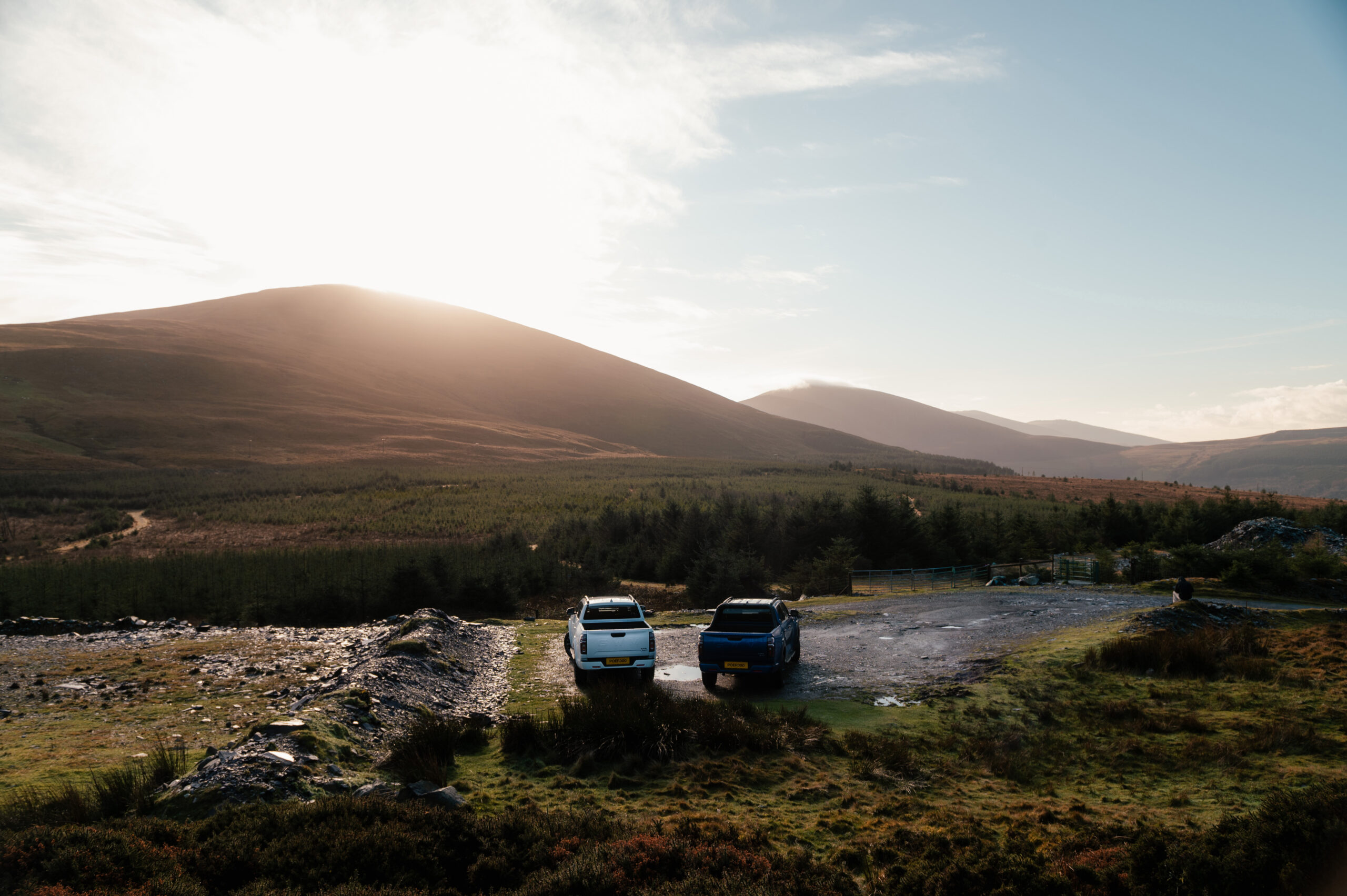 Two GWM POER 300s on a hill overlooking a sunrise setting. 