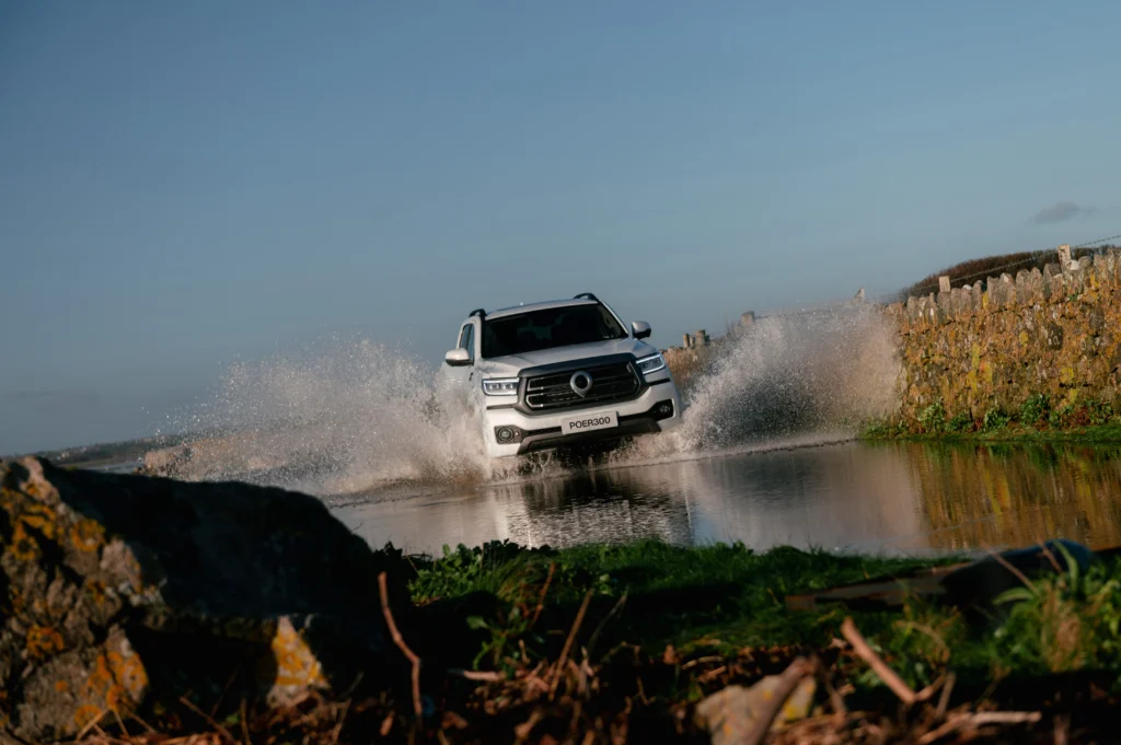 White GWM POER 300 driving through large puddle.