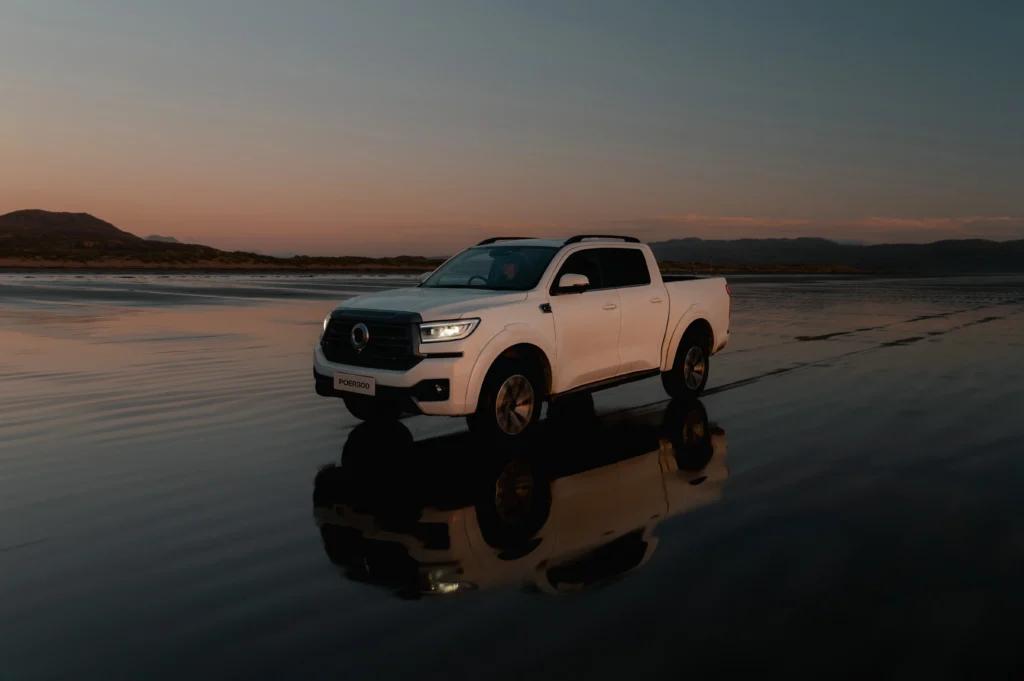 White POER 300 driving on wet beach with reflection