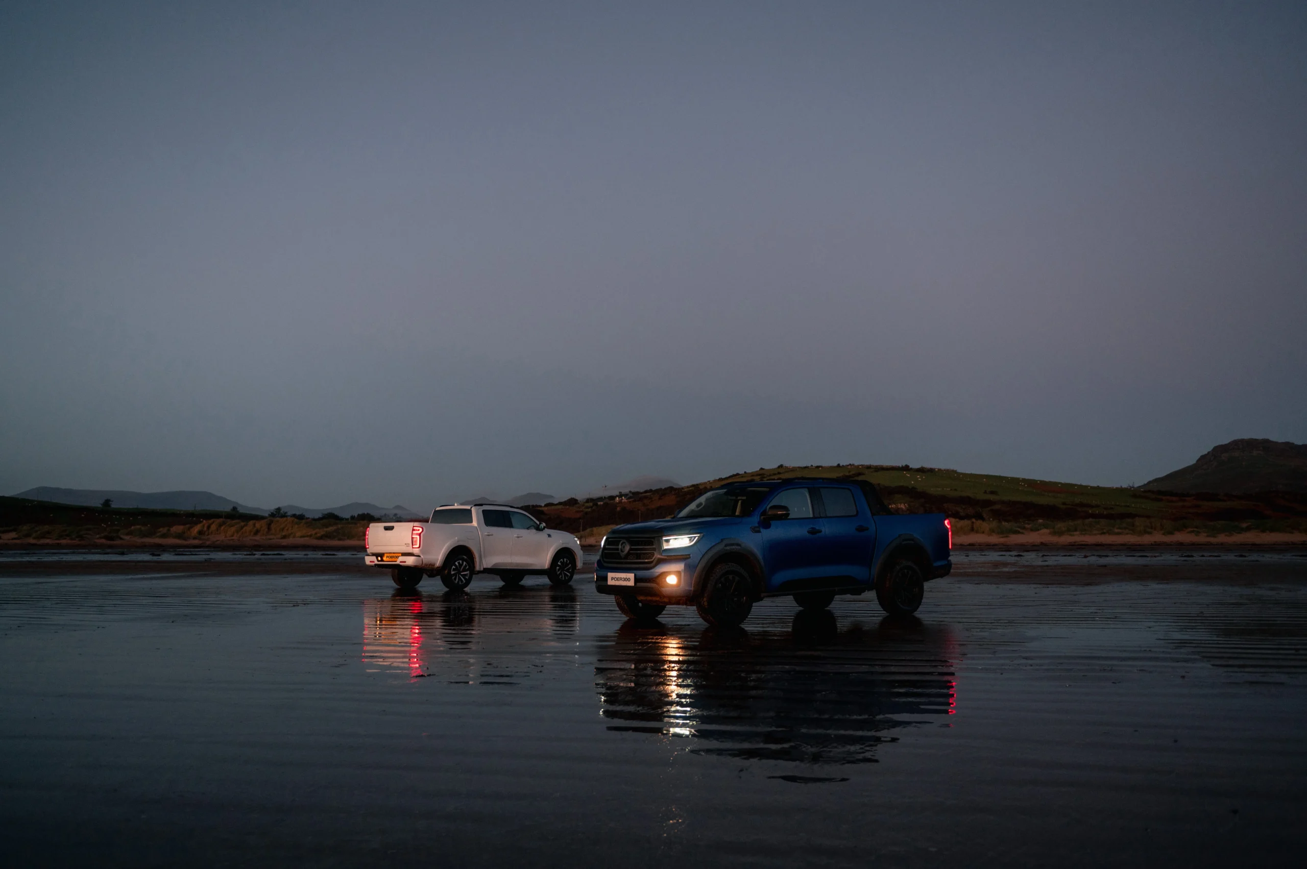 White and blue GWM POER 300 on the beach after a sunset.